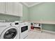 Efficient laundry room with modern washer and dryer, ample counter space, and storage cabinets at 3324 Thomas Rd, Raleigh, NC 27607