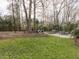 Large grassy backyard with an outdoor kitchen, patio with fire pit, and well-maintained landscaping at 3359 Hampton Rd, Raleigh, NC 27607