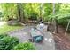 Landscaped backyard featuring a stone patio, outdoor kitchen with built-in grill, and dining area, perfect for entertaining at 3359 Hampton Rd, Raleigh, NC 27607