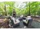 Outdoor living area with a stone fireplace, plush seating, and a serene setting, ideal for relaxing and entertaining at 3359 Hampton Rd, Raleigh, NC 27607