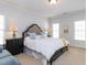 Bright bedroom features a large bed with tufted headboard, complemented by two side tables and three windows at 3359 Hampton Rd, Raleigh, NC 27607