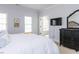 Well-lit bedroom showcasing a large bed, dresser, and an arched doorway leading to another room at 3359 Hampton Rd, Raleigh, NC 27607