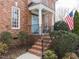Inviting front entrance with brick steps, black railings, and a blue door at 3359 Hampton Rd, Raleigh, NC 27607