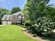 Beautiful brick home featuring a manicured lawn, mature trees, and flowering shrubs at 3359 Hampton Rd, Raleigh, NC 27607