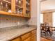 Kitchen with wooden cabinets, granite counters, and hardwood floors adjacent to the dining area at 3359 Hampton Rd, Raleigh, NC 27607
