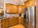 Kitchen with stainless steel refrigerator, wooden cabinets, granite counters, and hardwood flooring at 3359 Hampton Rd, Raleigh, NC 27607