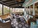 Inviting covered patio with wicker furniture and stylish rug, perfect for outdoor entertaining around the stone fire pit at 3359 Hampton Rd, Raleigh, NC 27607