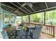 Inviting screened-in porch with comfortable seating, a stone fire pit, and a view of the lush, private backyard at 3359 Hampton Rd, Raleigh, NC 27607