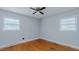 Inviting bedroom with hardwood floors, ceiling fan, and dual windows, offering a bright space at 4166 Nc 119, Mebane, NC 27302