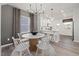 Dining area with modern chandelier adjacent to a kitchen and living room at 521 Providence Springs Ln, Fuquay Varina, NC 27526