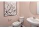 Powder room with modern pedestal sink, white toilet and an artwork at 609 Dorset Stream Dr, Fuquay Varina, NC 27526