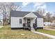 A cozy home with gray siding, a covered front porch, and a manicured lawn at 628 East Ave, Henderson, NC 27536