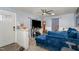 Cozy living room with a large blue sofa, ceiling fan, and neutral walls at 628 East Ave, Henderson, NC 27536