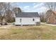 Back of the house with vinyl siding, a small deck, and a grass lawn at 628 East Ave, Henderson, NC 27536