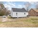 A small house with vinyl siding and a small deck, complemented by a grassy backyard at 628 East Ave, Henderson, NC 27536