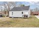 View of the back of a house, featuring vinyl siding, small deck, and a grassy yard at 628 East Ave, Henderson, NC 27536