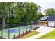 Bright pickleball court surrounded by a black fence for security and lush landscaping at 660 Sun Meadow Dr, Wake Forest, NC 27587