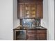 Stylish bar area featuring dark wood cabinets, a granite countertop, and a wine refrigerator at 6829 Palaver Ln, Cary, NC 27519