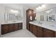 Dual vanities in a luxurious bathroom with matching dark wood cabinets and marble countertops at 6829 Palaver Ln, Cary, NC 27519