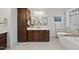 Elegant bathroom featuring a marble countertop, dark wood cabinets, and a freestanding soaking tub at 6829 Palaver Ln, Cary, NC 27519