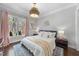 Cozy bedroom featuring a large window with scenic views, complemented by elegant decor and hardwood floors at 6829 Palaver Ln, Cary, NC 27519