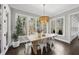 Sunlit dining room with large windows, hardwood floors, and modern chandelier at 6829 Palaver Ln, Cary, NC 27519