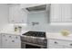 Close up of gourmet range and pot filler with bright white cabinets and subway tile at 6829 Palaver Ln, Cary, NC 27519