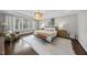 Serene primary bedroom featuring large windows and hardwood floors at 6829 Palaver Ln, Cary, NC 27519
