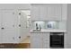 Convenient wet bar area with white cabinets, sink, and beverage refrigerator, ideal for entertaining guests at 6829 Palaver Ln, Cary, NC 27519