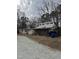 Two-story home with porch, deck and gravel driveway, surrounded by trees at 731 Latimer St, Hillsborough, NC 27278