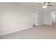 Well-lit bedroom with neutral walls, carpet, and multiple doors at 83 Paper Birch Way, Fuquay Varina, NC 27526
