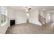 Bright, open living space with fireplace, hardwood floors, and staircase at 83 Paper Birch Way, Fuquay Varina, NC 27526