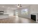 Open-concept living room with wood floors, stainless steel appliances, fireplace and backyard view at 83 Paper Birch Way, Fuquay Varina, NC 27526