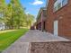 Back patio showcasing a brick home with a screened porch, staircase, landscaping and access to a lush green yard at 93 Shoreline Dr, Princeton, NC 27569