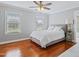 Bedroom with hardwood floors, two windows and a ceiling fan, creating a comfortable atmosphere at 93 Shoreline Dr, Princeton, NC 27569