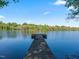 A straight on view of a wooden dock leading to the center of a calm lake reflecting the blue sky at 93 Shoreline Dr, Princeton, NC 27569