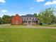 Beautiful two-story brick home with black shutters, white columns, and a well-manicured lawn at 93 Shoreline Dr, Princeton, NC 27569
