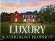 Stunning, two-story brick home with a covered front porch, manicured lawn, and professional landscaping at 93 Shoreline Dr, Princeton, NC 27569