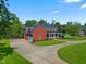 Spacious brick home featuring a circular driveway, lush landscaping, and an attached two-car garage at 93 Shoreline Dr, Princeton, NC 27569