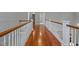 Hallway featuring hardwood floors and white painted railings at 93 Shoreline Dr, Princeton, NC 27569