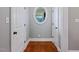 Hallway with hardwood floors, wainscoting, and a unique oval window at 93 Shoreline Dr, Princeton, NC 27569