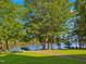 Scenic view of lake featuring a stone pathway and dock, surrounded by lush trees and greenery at 93 Shoreline Dr, Princeton, NC 27569