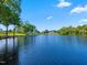 Wide lake view featuring calm waters, various houses along the shoreline, and lush greenery under a clear blue sky at 93 Shoreline Dr, Princeton, NC 27569