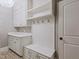 Bright mudroom features custom white cabinets and drawers, coat hooks, and designer tile flooring at 93 Shoreline Dr, Princeton, NC 27569