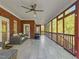 Screened in patio area featuring tile floors, brick walls, and neutral furniture at 93 Shoreline Dr, Princeton, NC 27569