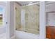 Stylish bathroom featuring a glass-enclosed tub/shower with marble tile at 93 Shoreline Dr, Princeton, NC 27569