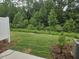 Backyard with green grass, wooden fence, and natural surroundings at 104 Lavender Ln, Clayton, NC 27520