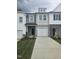 Charming townhome featuring a light gray and white exterior, a driveway, and a one-car garage at 104 Lavender Ln, Clayton, NC 27520