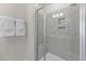 Modern bathroom shower with gray tiling, built-in niche, and glass door at 10533 Pleasant Branch Dr # 201, Raleigh, NC 27614