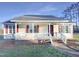 Charming one-story home features a welcoming front porch and red shutters under a clear blue sky at 1125 Field Meadows Dr, Zebulon, NC 27597